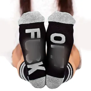 Detailed view of mid-tube socks featuring grey Fuck Off lettering on black cotton soles