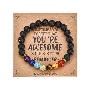 Macro view of lava stone chakra bracelet on a handmade kraft paper card holder