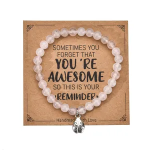 Pink zebra stone bead bracelet with metal heart charm on a brown kraft card display