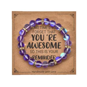Purple beaded bracelet with gold diamond accents on a brown kraft gift card packaging