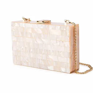 Detailed side view of pearlescent acrylic evening clutch with gold metal hardware and chain