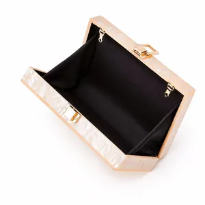 Detail view of the acrylic clutch interior with marble pattern and gold metal frame