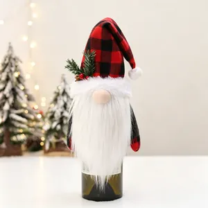 Close-up of Christmas gnome wine bottle cover with red plaid hat and pine decoration