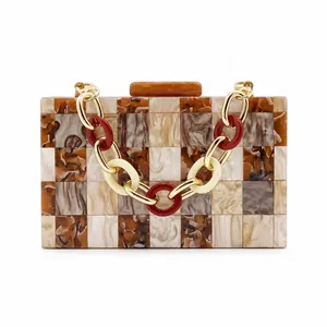 Detail of checkered acrylic evening clutch with marble texture and tricolor chain strap