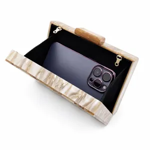 Detail view of the acrylic marble clutch interior fitting a smartphone and essentials