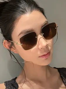 Close-up of semi-rimless square sunglasses with brown gradient lenses and gold metal temples