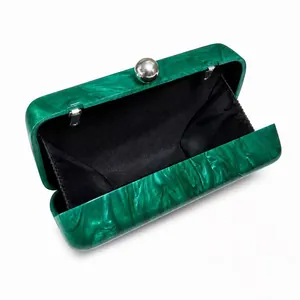 Detail of green marble acrylic clutch bag showing interior lining and ball clasp