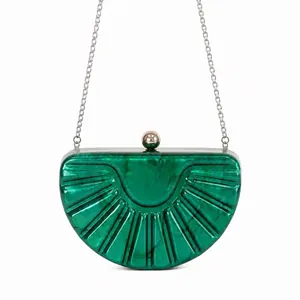 Detailed close-up of emerald green marble acrylic shell evening clutch with gold ball clasp