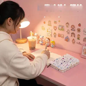 Close-up of a white plush notebook with colorful glitter stars in a cozy desk setting