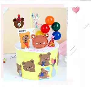 Detailed close-up of cartoon bear cake toppers with balloons and a mini party hat