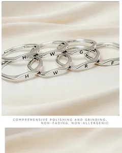Macro shot of minimalist wave rings with polished surface and initial engravings