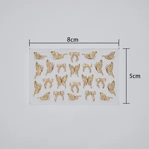 Detail of colorful butterfly nail art stickers with gold outlines and pink gradients
