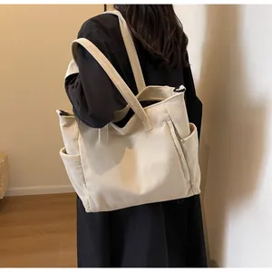 Side view of beige corduroy tote bag showing side pocket and textured fabric on model