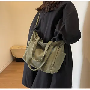 Detail of army green corduroy tote bag featuring side pockets and adjustable shoulder strap