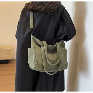 Detail of olive green corduroy tote bag showing striped texture and canvas shoulder strap