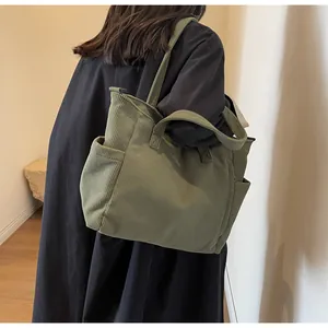 Detail of army green corduroy tote bag showing side pocket and textured fabric on model
