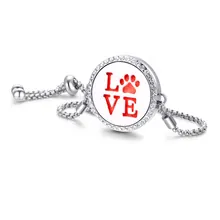 Macro detail of silver aromatherapy bracelet with red LOVE and paw print locket charm