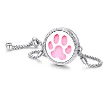 Close-up of adjustable stainless steel bracelet with pink paw print and crystal details