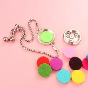 Macro view of aromatherapy diffuser bracelet with colorful felt pads on pink background