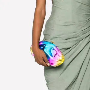 Macro detail of an iridescent wavy acrylic evening clutch with gold metal clasp