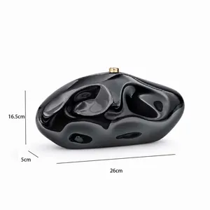 Detailed view of black pebble acrylic evening bag with gold clasp and size dimensions