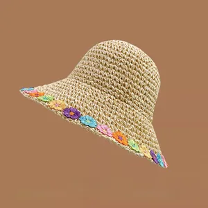 Close-up of colorful floral embroidery on the edge of a wide brim straw sun hat