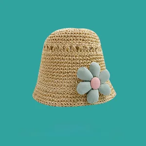 Detail of hollow-out straw sun hat with a large turquoise fabric flower decoration