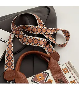 Detail of canvas tote bag with ethnic geometric pattern wide strap and leather trim