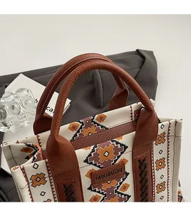 Detail of bohemian canvas tote with leather straps and intricate ethnic geometric patterns