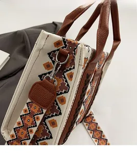 Detail of detachable metal hook and durable leather handle on ethnic canvas tote bag