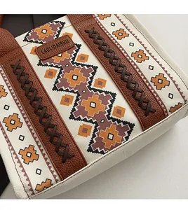 Detailed view of ethnic geometric canvas fabric and leather handle on a large tote bag