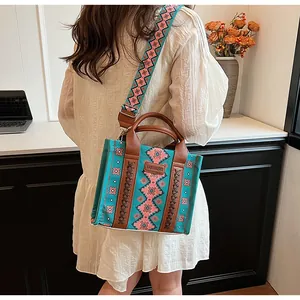 Detail of bohemian canvas tote with ethnic embroidery and adjustable wide woven strap