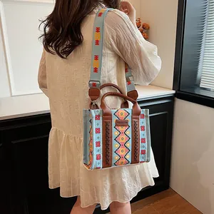 Ethnic geometric canvas tote bag with brown leather handles and wide shoulder strap
