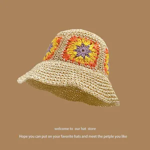 Handmade crochet sun hat with colorful floral patterns and wide brim in beige color