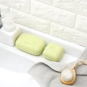 Portable light green travel soap box set with leakproof lid on bathroom sink counter