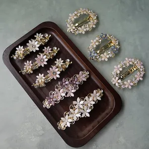 Close-up of vintage flower hair clips with colorful resin petals and sparkling rhinestones