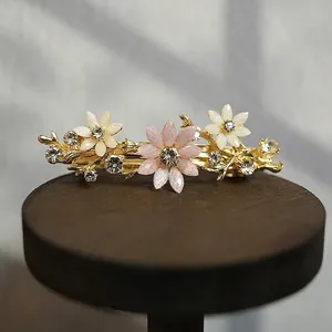 Detail view of floral alloy hair clip with pink rhinestones and size measurements