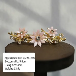 Detail shot of vintage pink floral hair clip with rhinestones and alloy spring clamp