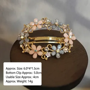 Detail of vintage flower hair clip with rhinestones and gems on a wooden stand