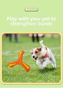 Three-blade orange EVA foam boomerang flying in outdoor grass with a dog catching it