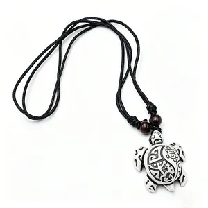 Gros plan du pendentif tortue aux motifs tribaux avec cordon noir et perles en bois