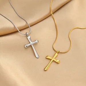Détail de colliers croix or et argent avec finition polie sur fond de satin