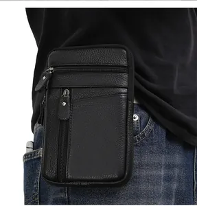 Detail of black pebbled leather waist bag showing multiple zippered compartments on waist