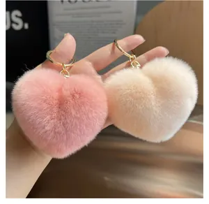 Détails de porte-clés cœurs en fausse fourrure rose et crème avec anneau doré