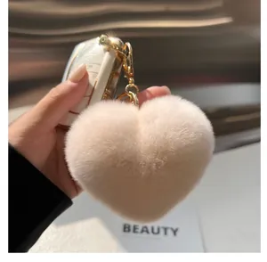 Gros plan d'un porte-clés en forme de cœur en fausse fourrure rose avec fermoir doré
