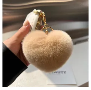 Détail d'un porte-clés en peluche en forme de cœur sur un sac avec matériel doré