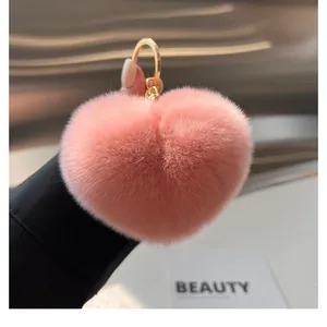 Détail du porte-clés cœur en fausse fourrure rose avec anneau en métal doré
