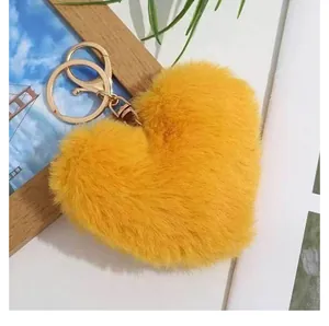 Gros plan du porte-clés en peluche jaune en forme de cœur avec fermoir en métal doré