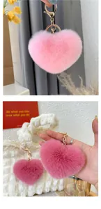 Détail du porte-clés coeur en fausse fourrure rose avec fermoir doré sur un sac blanc