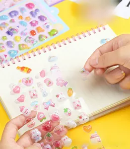 Close-up of hand peeling a 3D relief cartoon sticker with pink rabbit and heart designs